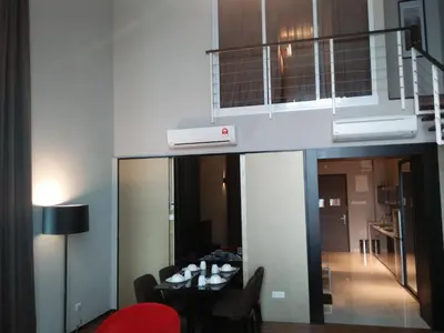 a living room with a dining table and a balcony at Urbano Luxury Maritime Suite in George Town