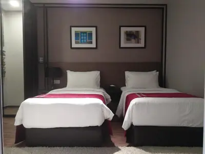 two beds in a hotel room with white and red sheets at Urbano Luxury Maritime Suite in George Town