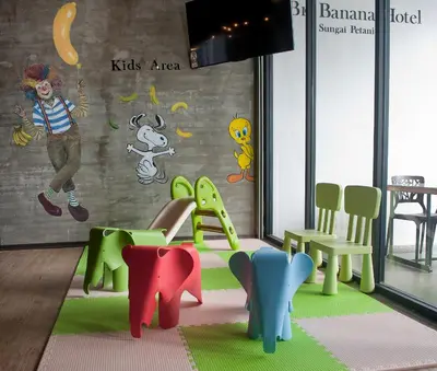 a room with colorful chairs and a wall with a mural at Big Banana Hotel, Sg Petani in Sungai Petani