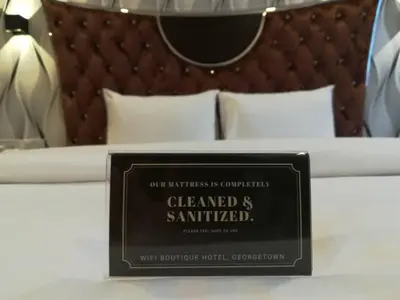 a sign sitting on top of a bed at Wifi Boutique Hotel in George Town