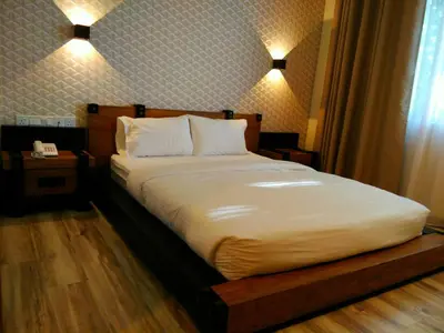 a bed in a bedroom with two lights on at Wifi Boutique Hotel in George Town