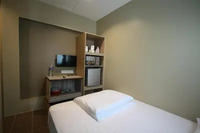 a small bedroom with a bed and a television at Shamrock Greenhill in Ipoh
