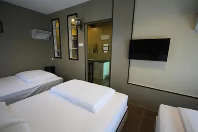 a room with two beds and a flat screen tv at Shamrock Greenhill in Ipoh