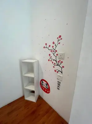 a white room with a shelf and a wall with a branch at Compact Cozy Duplex Studio at Bayan Lepas in Bayan Lepas