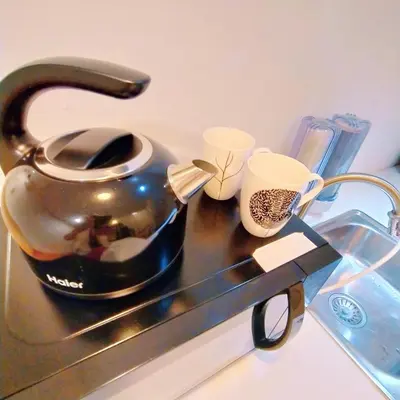 a tea kettle and two cups on a counter at Compact Cozy Duplex Studio at Bayan Lepas in Bayan Lepas