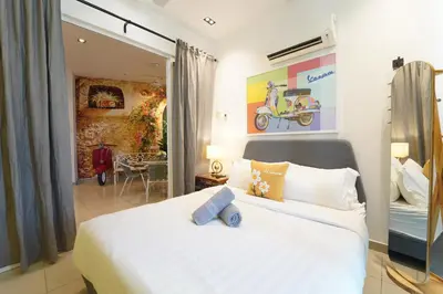 a bedroom with a white bed and a living room at \u5bb6 Majestic Ipoh in Ipoh