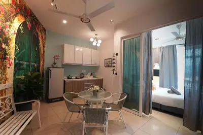 a kitchen and dining room with a table and a bed at \u5bb6 Majestic Ipoh in Ipoh