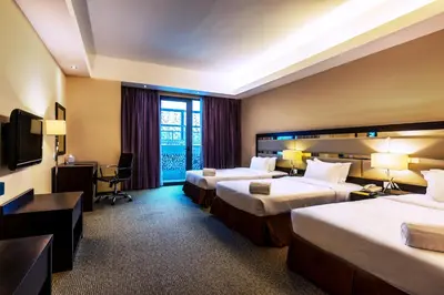 a hotel room with two beds and a television at Ixora Hotel Penang in Perai