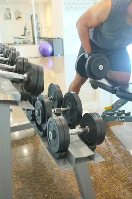 a man in a gym with a row of weights at Ixora Hotel Penang in Perai