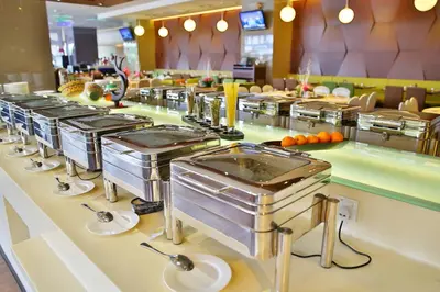 a buffet line of stainless steel food stations in a restaurant at Ixora Hotel Penang in Perai