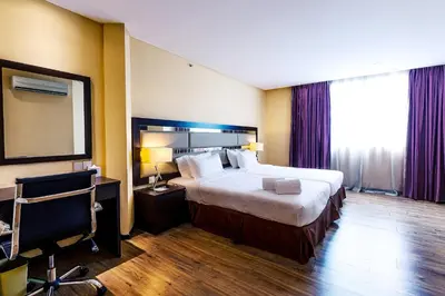 a hotel room with a large bed and a mirror at Ixora Hotel Penang in Perai