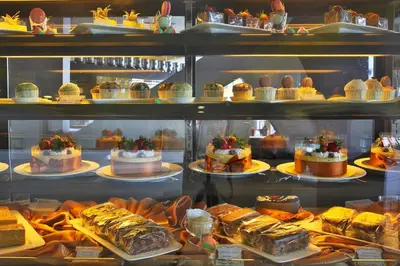 a display case filled with lots of cakes and desserts at Ixora Hotel Penang in Perai