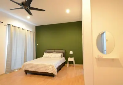 a green bedroom with a bed and a ceiling fan at Decozy Homestay (14pax++) in Ipoh