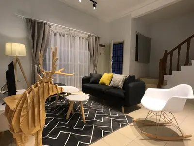 a living room with a black couch and a chair at beNordic -8-10mins Tambun Water Park-10-14Pax in Ipoh