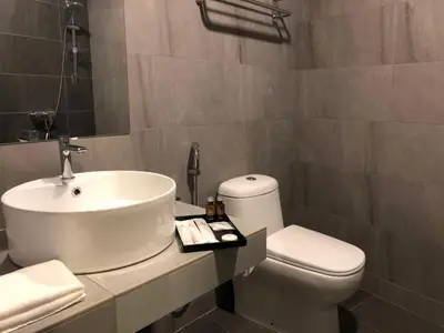 a bathroom with a white sink and a toilet at K Boutique Hotel in Teluk Intan