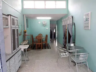 a room with chairs and a table and a dining room at Homestay Ustaz in Taiping