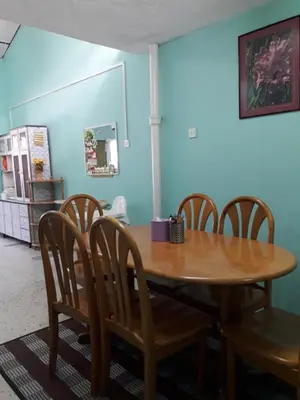 a dining room with a wooden table and chairs at Homestay Ustaz in Taiping