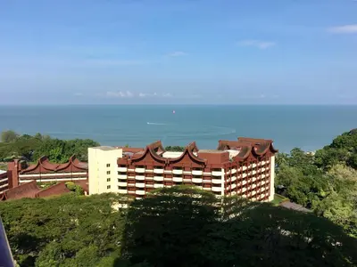 a building on a hill with the ocean in the background at The Ferringhi Sea View at Sri Sayang in Batu Ferringhi