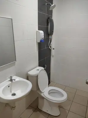 a bathroom with a toilet and a sink and a phone at Hotel Star Inn in Teluk Intan