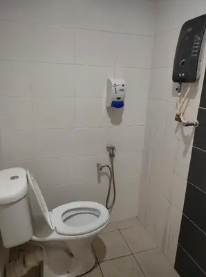 a bathroom with a toilet and a phone on the wall at Hotel Star Inn in Teluk Intan