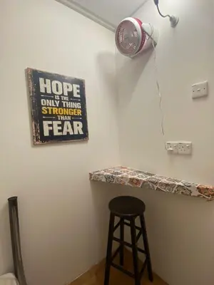 a fan and a stool in a room with a counter at Hikers Sleep Port Guesthouse in Cameron Highlands