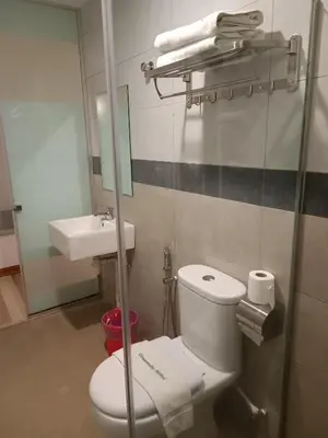 a bathroom with a toilet and a sink and a mirror at Greencity Hotel in Sungai Petani