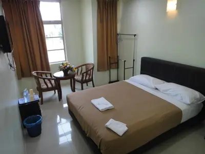 a bedroom with a large bed with two towels on it at Mines Inn Hotel in Gua Musang