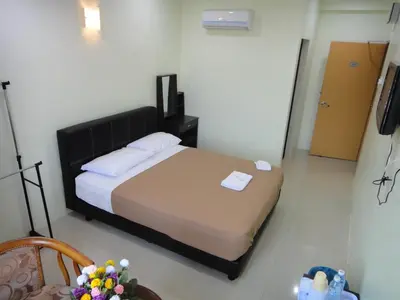 a bedroom with a bed in a room with a television at Mines Inn Hotel in Gua Musang