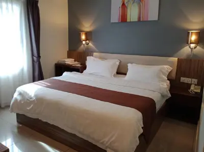 a bedroom with a large bed in a hotel room at Oscar Suites Hotel in Sitiawan