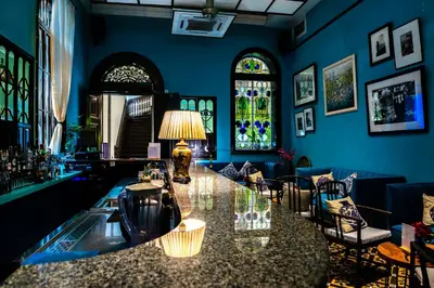 a blue room with a bar with a lamp and chairs at Cheong Fatt Tze - The Blue Mansion in George Town