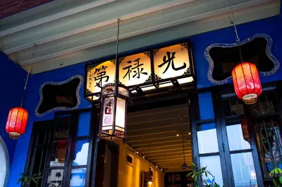 a restaurant with chinese signs on the side of a building at Cheong Fatt Tze - The Blue Mansion in George Town