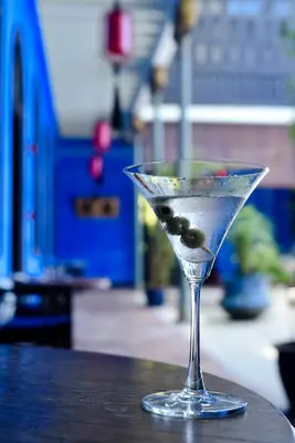 a martini glass with olives in it sitting on a table at Cheong Fatt Tze - The Blue Mansion in George Town