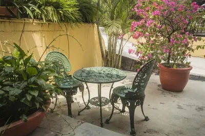a patio with two chairs and a table with flowers at Anggerik Lodging in George Town
