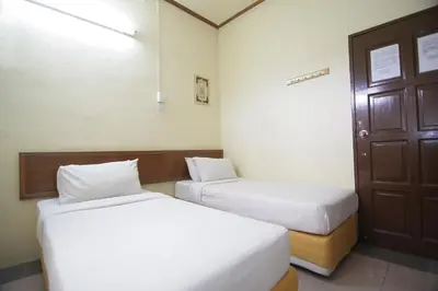 a room with two beds and a door at Anggerik Lodging in George Town