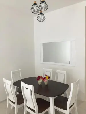 a dining room with a black table and white chairs at Cameron Prima Apartment @ Cameron Jaya in Cameron Highlands