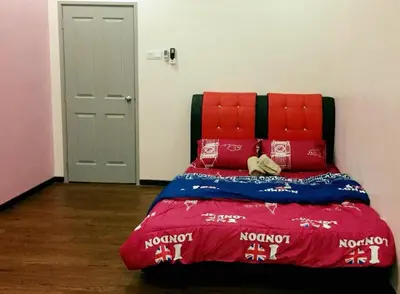a bed with a red head board and red pillows at Bukit Banyan Homestay Sungai Petani in Sungai Petani