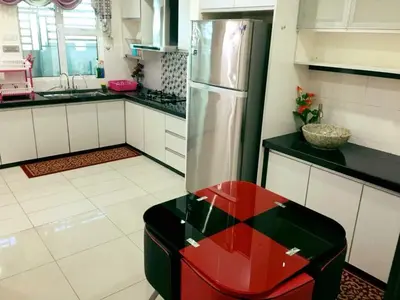 a kitchen with a refrigerator and a red stool at Bukit Banyan Homestay Sungai Petani in Sungai Petani