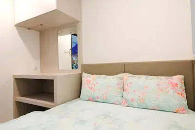 a bedroom with a bed with two pillows and a mirror at H2H - Swiss Home - Majestic Ipoh in Ipoh