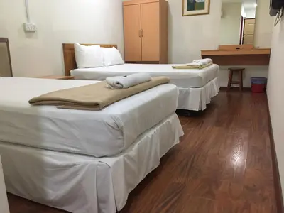 three beds in a hotel room with towels on them at Hotel Sri Malim in Tanjung Malim