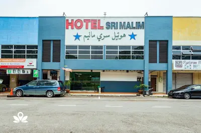 a hotel with two cars parked in front of it at Hotel Sri Malim in Tanjung Malim