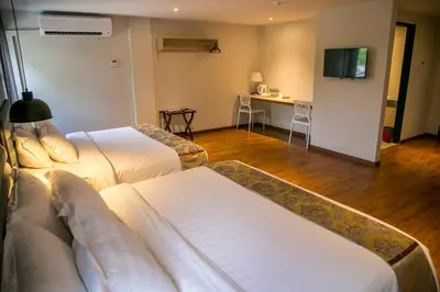 a hotel room with two beds and a television at Apple Suites Hotel in Sitiawan