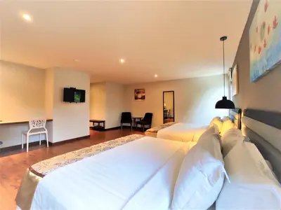 a hotel room with two beds and a tv at Apple Suites Hotel in Sitiawan