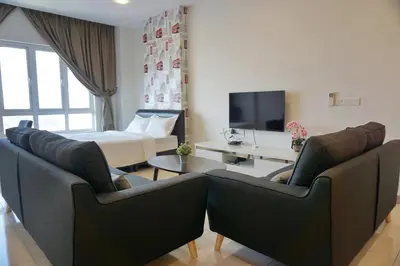a living room with two chairs and a bed at PM Octagon Ipoh Suites & Apartment 3 in Ipoh