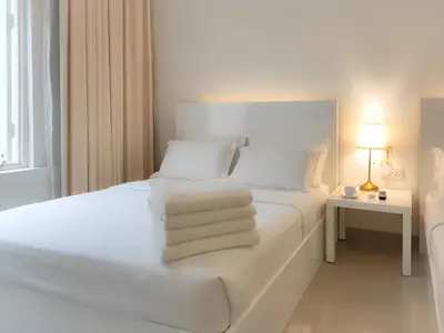 a white bedroom with a white bed with towels on it at Chulia Heritage Hotel in George Town