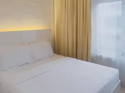 a white bed with white pillows and a window at Chulia Heritage Hotel in George Town