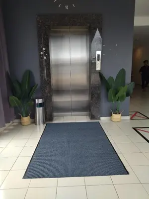 an elevator lobby with a blue mat in front of a door at Sp Central Hotel in Sungai Petani