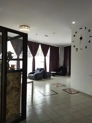 a living room with a couch and a clock on the wall at Sp Central Hotel in Sungai Petani