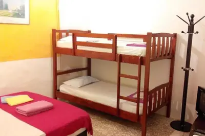 a bunk bed room with two bunk beds and a table at Cocoa Mews Cafe and Homestay in George Town