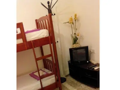 a room with two bunk beds and a television at Cocoa Mews Cafe and Homestay in George Town