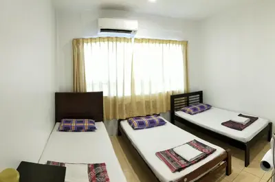 a room with two beds and a window at Hotel Tanjong in Tanjung Malim